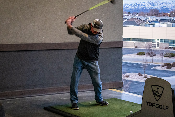 Man swinging club at Topgolf