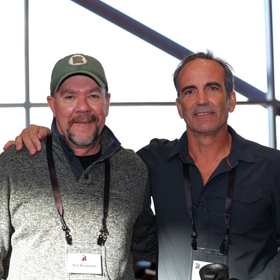 Two men in casual clothes posing for photo