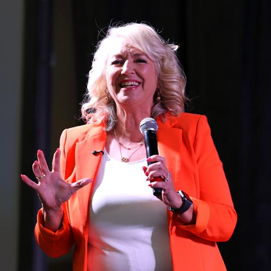 Sydne Jacques in orange blazer on stage