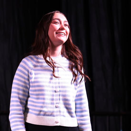 Young women in striped cardigan on stage